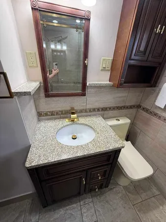 a bathroom with a granite countertop sink and a mirror