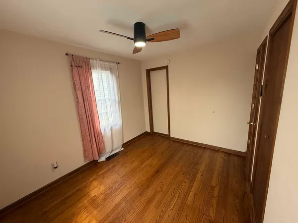 an empty room with wooden floor and a window