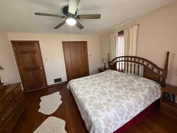 a bedroom with a bed window and a dresser