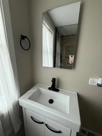 a bathroom with a sink toilet and mirror