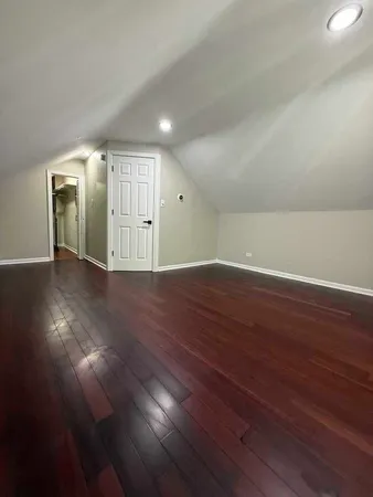 an empty room with wooden floor & windows