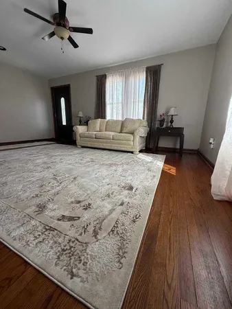 a living room with a bed furniture and a wooden floor