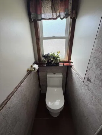 a white toilet sitting next to a window