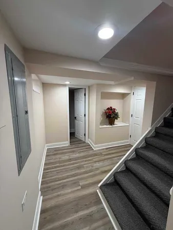 a view of a hallway to a house with wooden floor and stairs