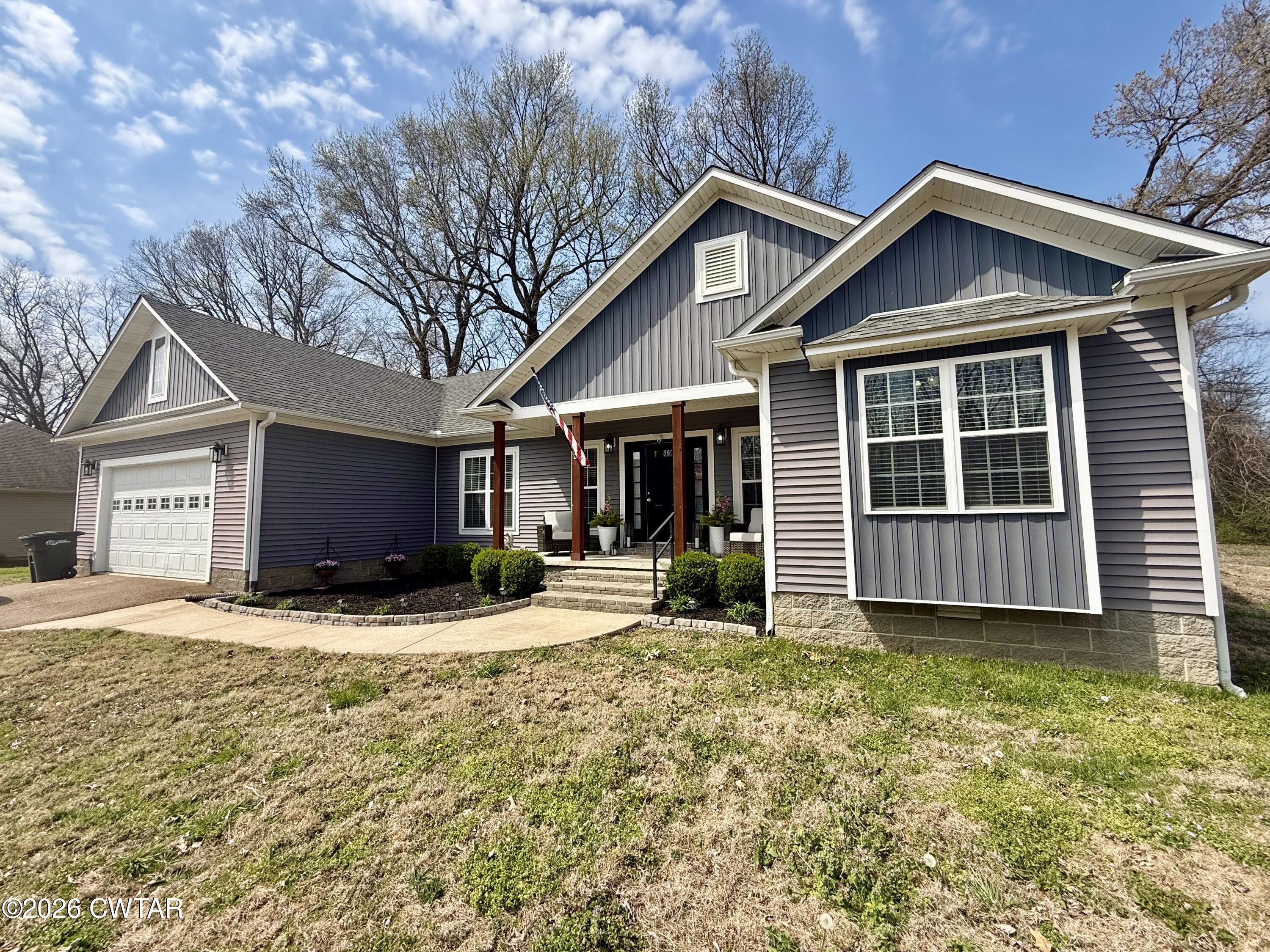 a front view of a house with a yard outdoor seating and garage