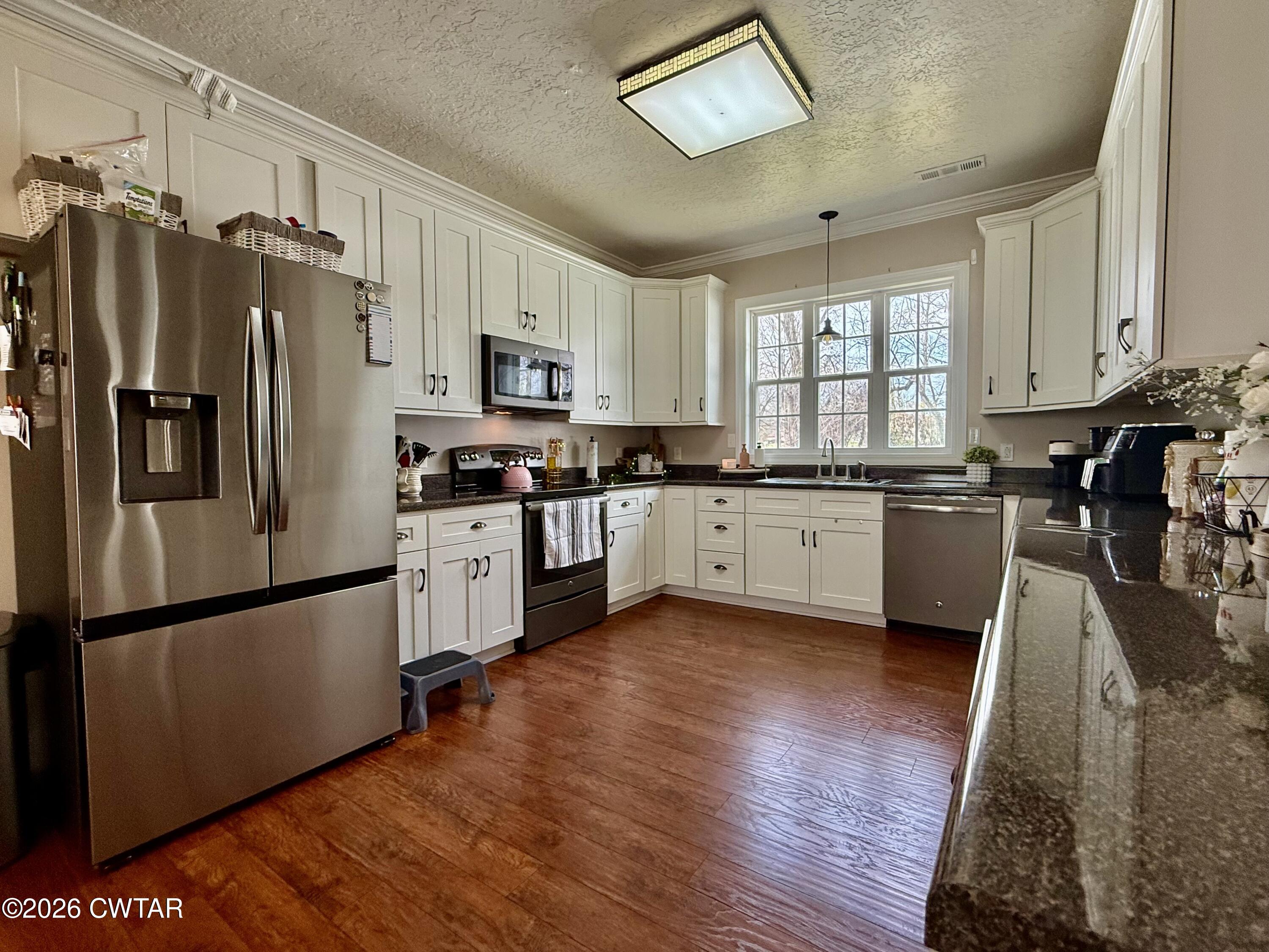 601 Locust Street Troy, TN 38260 - Photo 7 of 22 a kitchen with a refrigerator a sink and cabinets