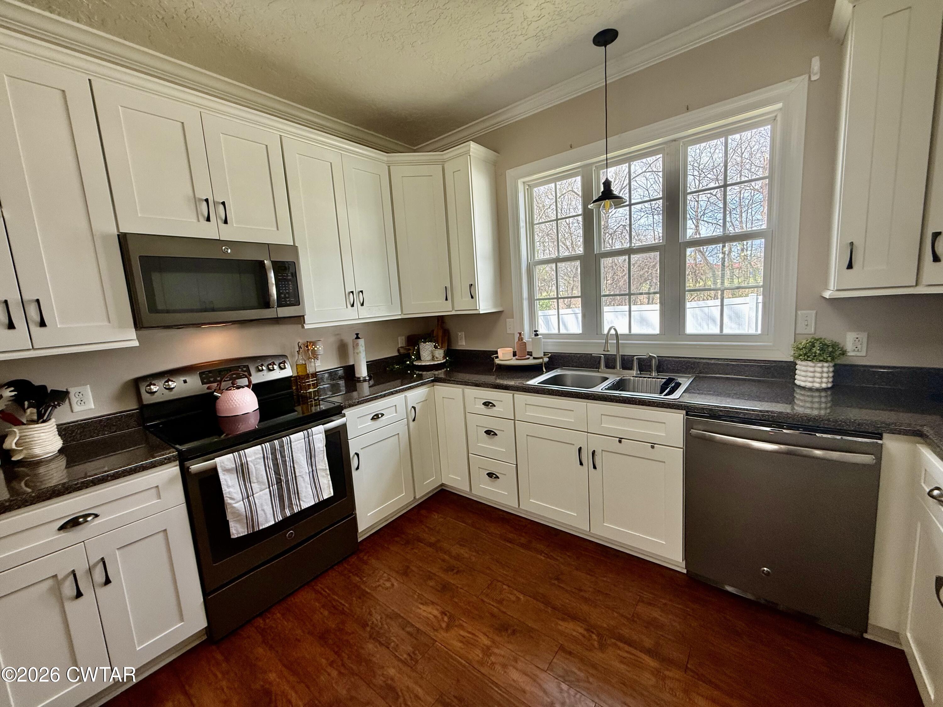 601 Locust Street Troy, TN 38260 - Photo 8 of 22 a kitchen with granite countertop white cabinets and black stainless steel appliances
