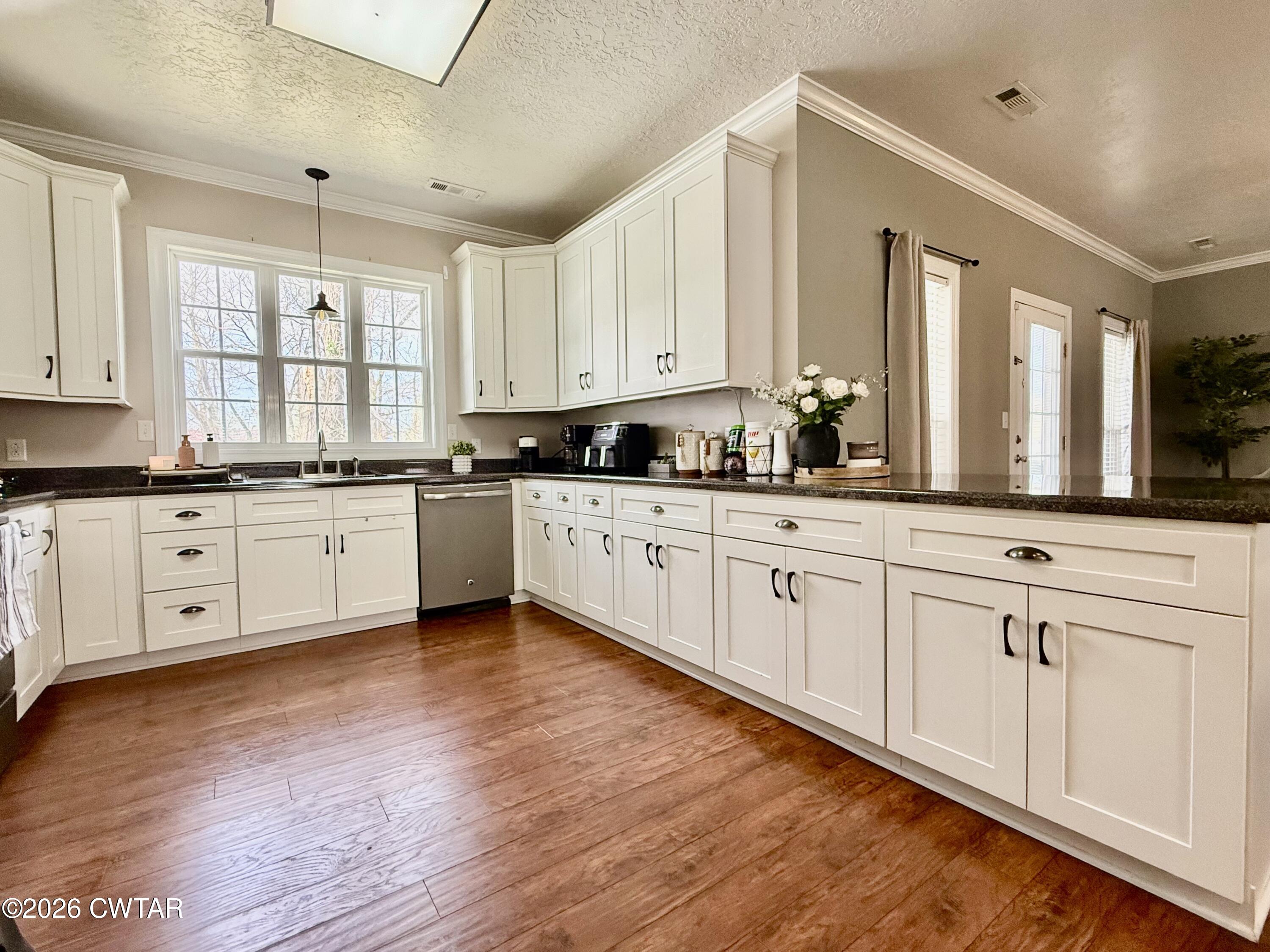 601 Locust Street Troy, TN 38260 - Photo 9 of 22 a large white kitchen with cabinets and wooden floor