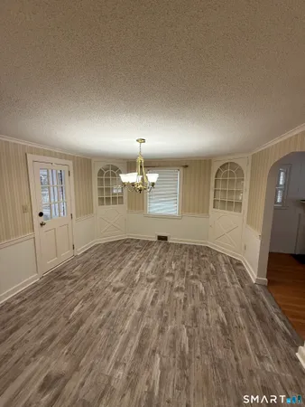 a view of empty room with wooden floor