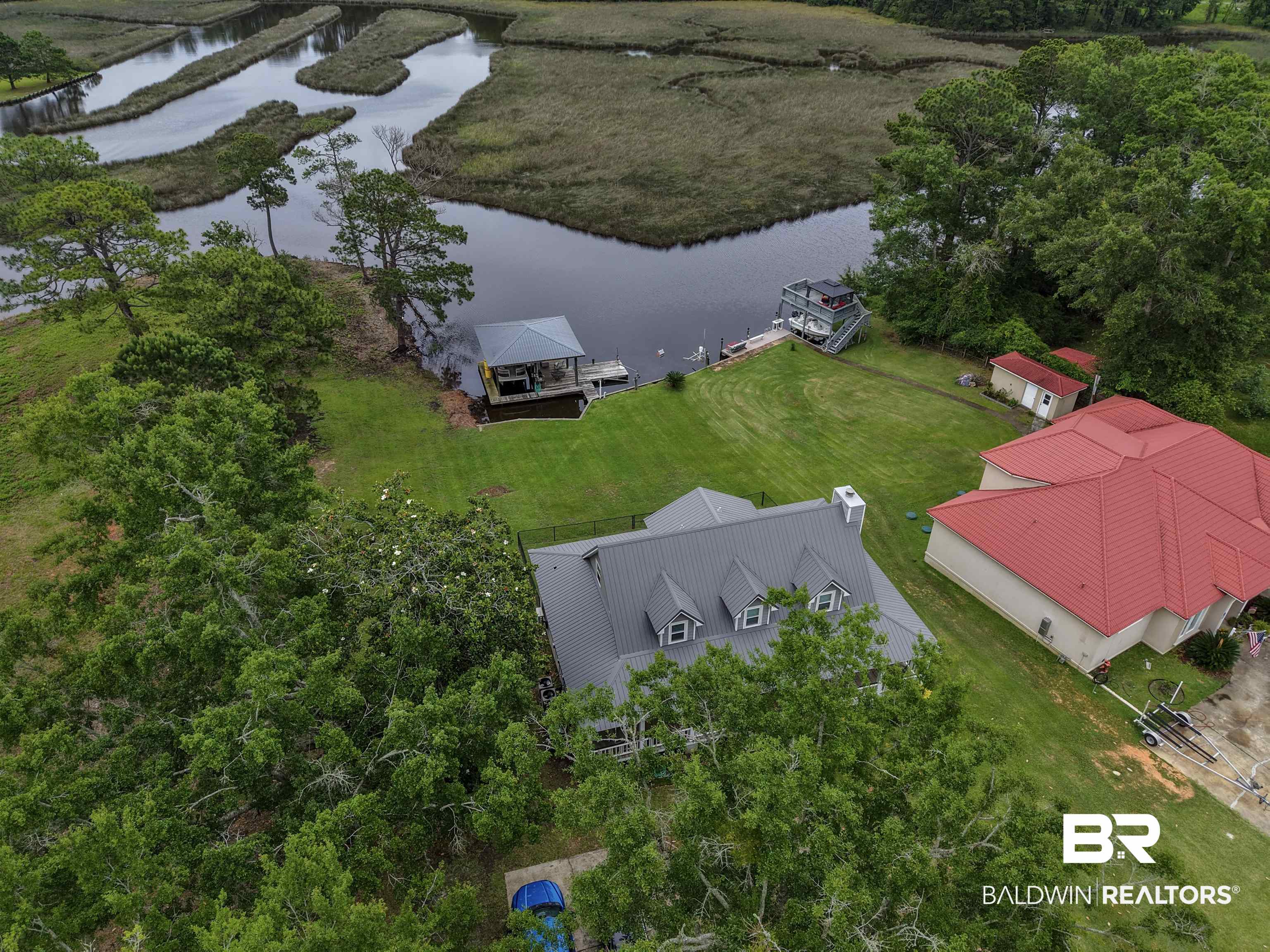 12171 Marguerite Drive Coden, AL 36523 - Photo 39 of 44 Waterfront property featuring a private boat dock, covered boat lift, and an additional smaller dock