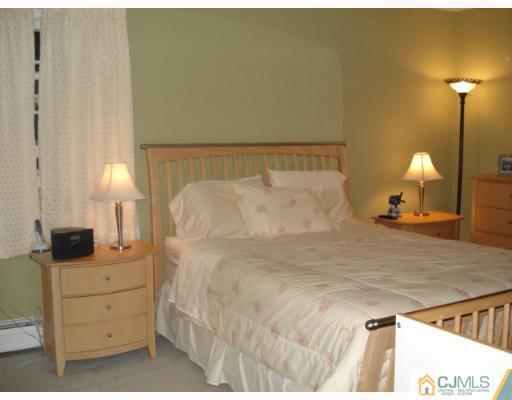 45 Lynnwood Road Edison, NJ 08820 - Photo 7 of 8 a bedroom with a bed and a lamp