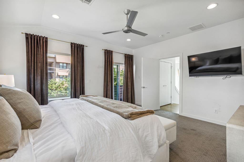 5015 Manett Street, Unit 101 Dallas, TX 75206 - Photo 18 of 25 a bedroom with a large bed and a flat screen tv