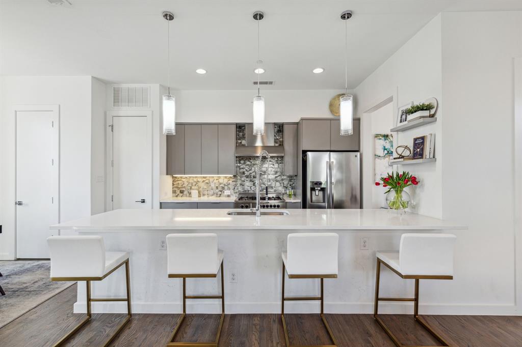 5015 Manett Street, Unit 101 Dallas, TX 75206 - Photo 6 of 25 a kitchen with kitchen island cabinets and chairs in it
