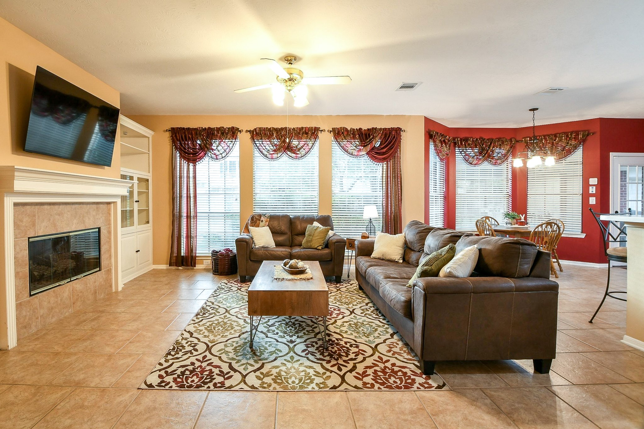 20423 Forest Drive Spring, TX 77388 - Photo 11 of 49 This spacious living room features a cozy fireplace and ample natural light from the large windows overlooking the backyard. The open layout flows into the kitchen dining area, creating a welcoming atmosphere for family gatherings.