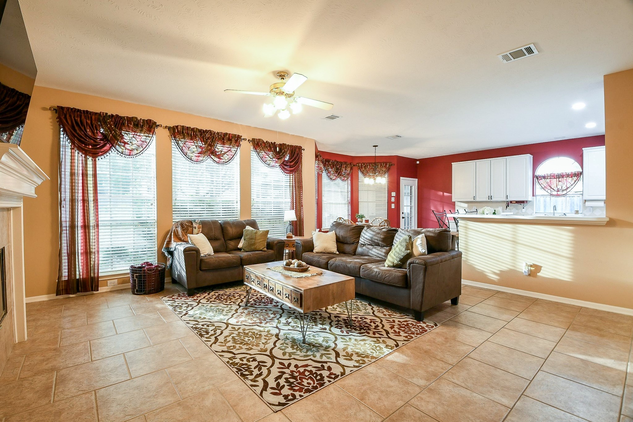 20423 Forest Drive Spring, TX 77388 - Photo 13 of 49 The spacious living area features large windows for natural light, plenty of space for various seating arrangements, and a transition to an open kitchen with white cabinetry.