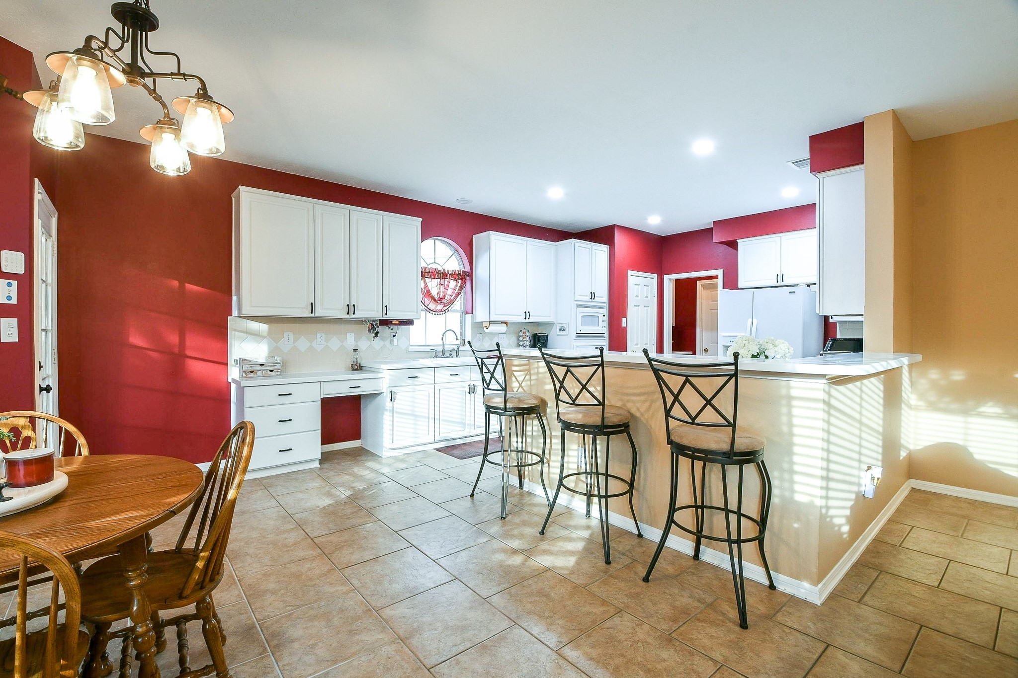20423 Forest Drive Spring, TX 77388 - Photo 14 of 49 This inviting kitchen features recessed ceiling lights, white cabinetry, and natural light. The breakfast bar and adjacent dining area provide a cozy space for meals.