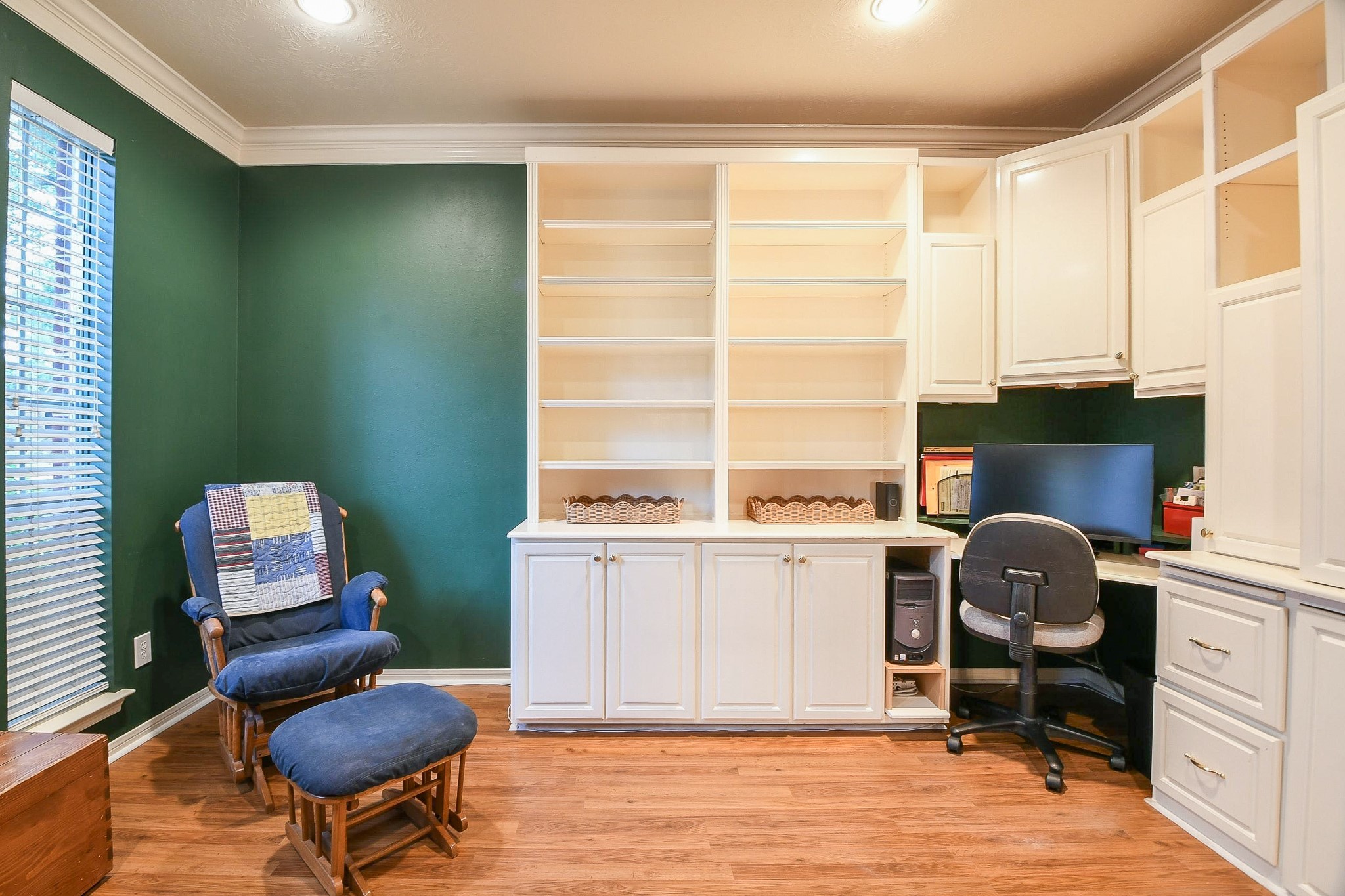 20423 Forest Drive Spring, TX 77388 - Photo 9 of 49 This cozy home office features built-in white shelving, and a desk area with ample storage. Natural light streams in through the windows, and there's room for an additional chair for relaxation.