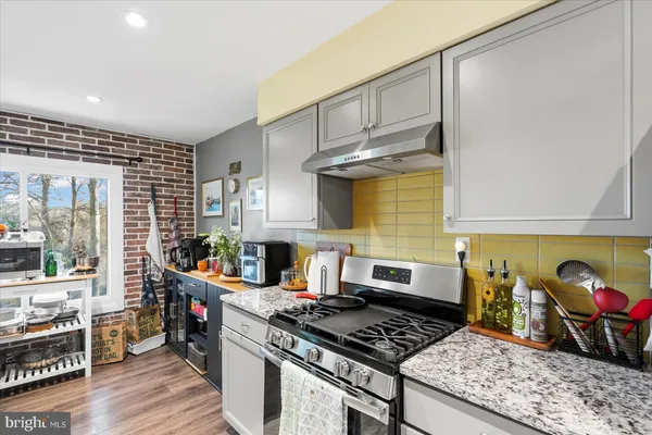 a kitchen with stainless steel appliances granite countertop a stove and a wooden cabinets
