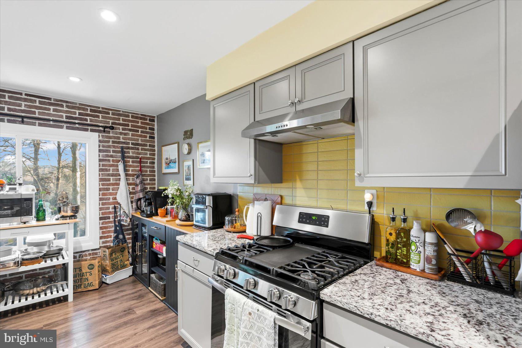 5239 West Running Brook Road, Unit 302 Columbia, MD 21044 - Photo 11 of 33 a kitchen with stainless steel appliances granite countertop a stove and a wooden cabinets