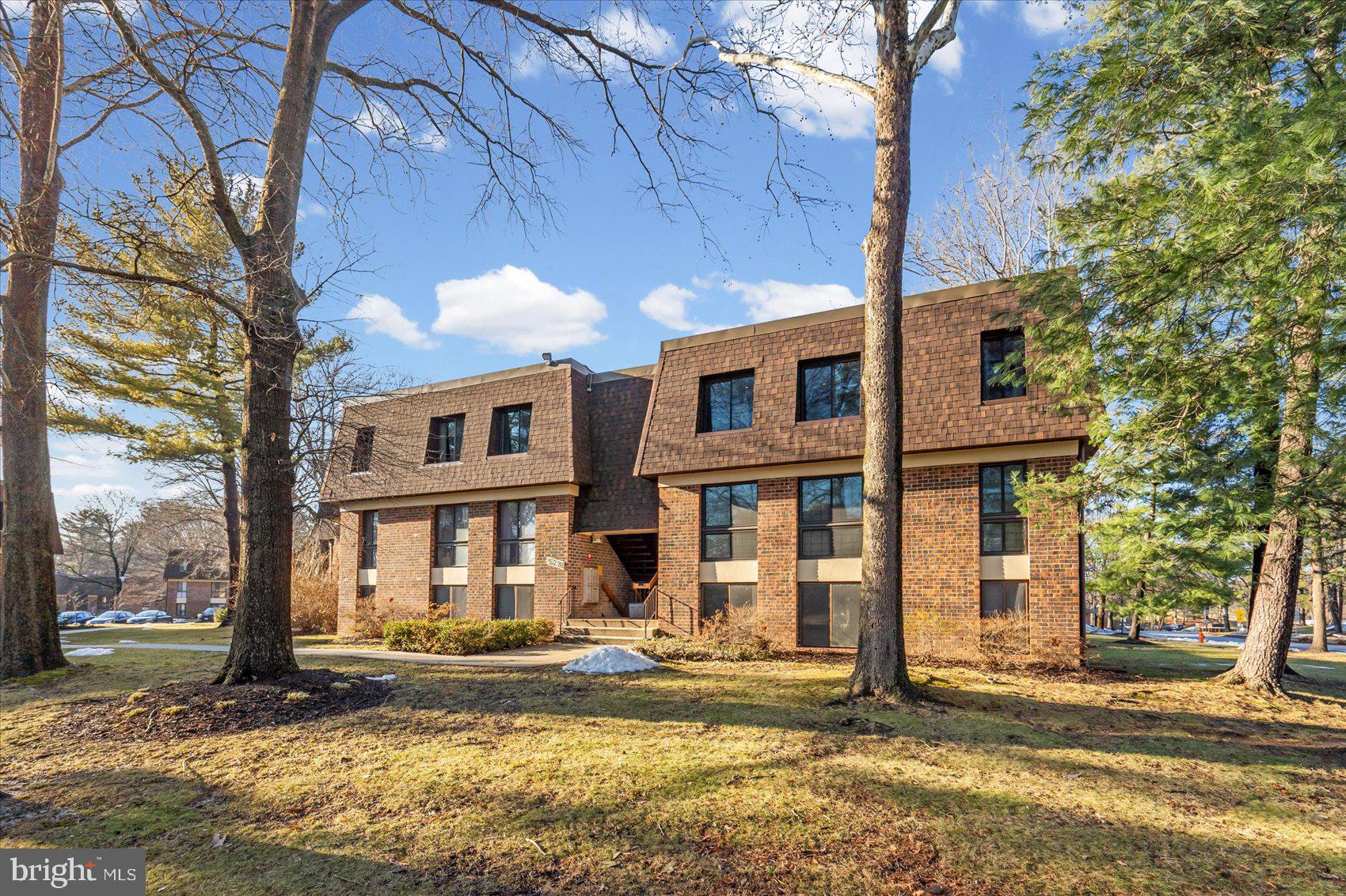 5239 West Running Brook Road, Unit 302 Columbia, MD 21044 - Photo 32 of 33 a view of a brick house with a large windows and a big tree