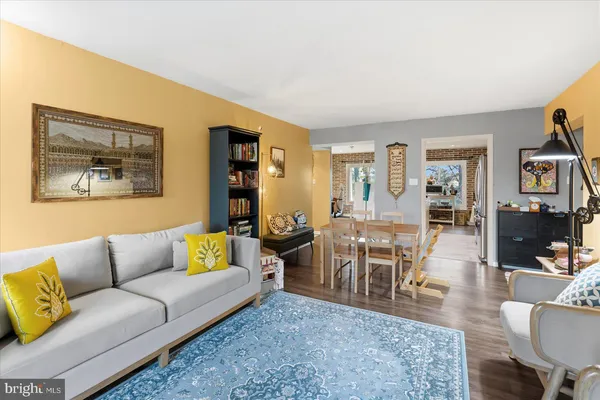 a living room with furniture dining table and paintings on the wall