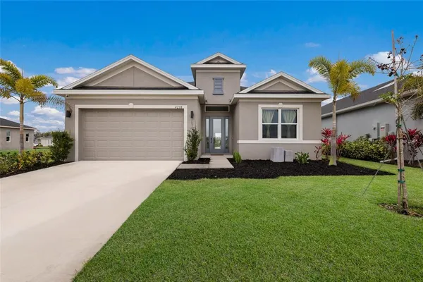 a front view of a house with a yard and garage