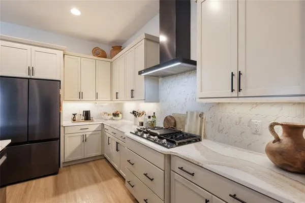a kitchen with a sink a refrigerator and cabinets