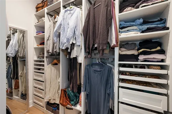a view of walk in closet with clothes and shoes