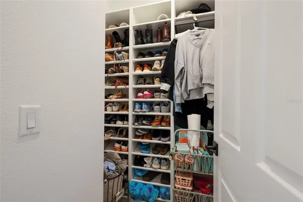 a view of walk in closet with clothes and shoes
