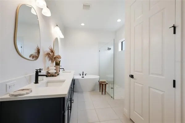 a en suite bathroom with a double vanity sink and a mirror