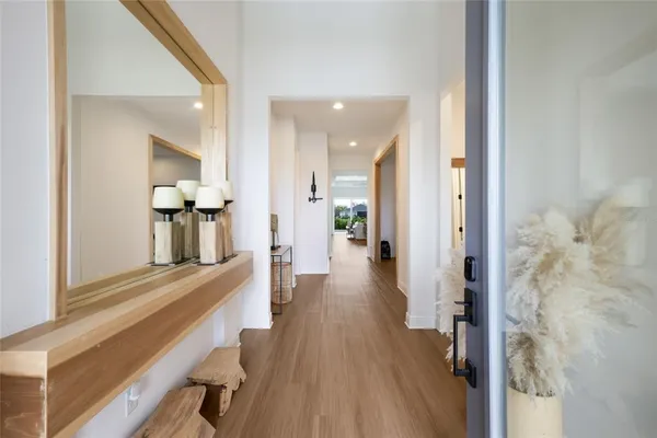 a view of a hallway with wooden floor and staircase