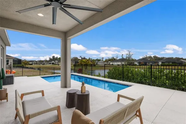a view of house with swimming pool and seating space