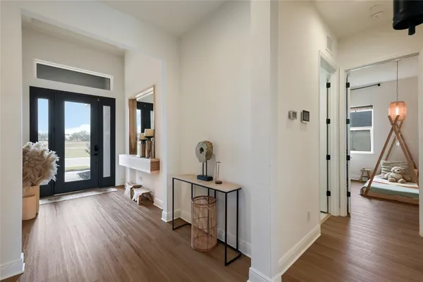 a view of a hallway with wooden floor and a living room