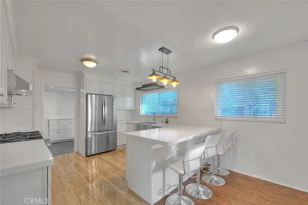 a kitchen with stainless steel appliances granite countertop a sink refrigerator and microwave