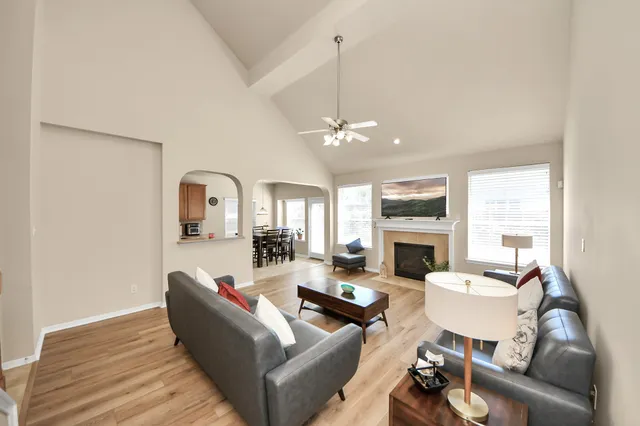 a living room with furniture a fireplace and a chandelier