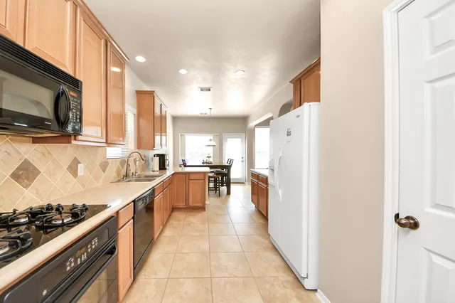 a kitchen with stainless steel appliances a stove a microwave and a refrigerator