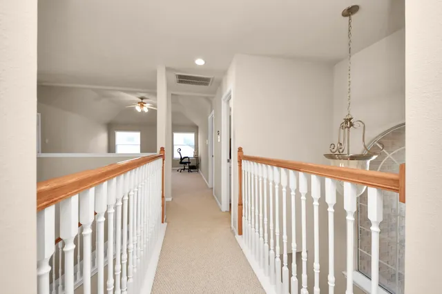 a view of a hallway with a living room a chandelier