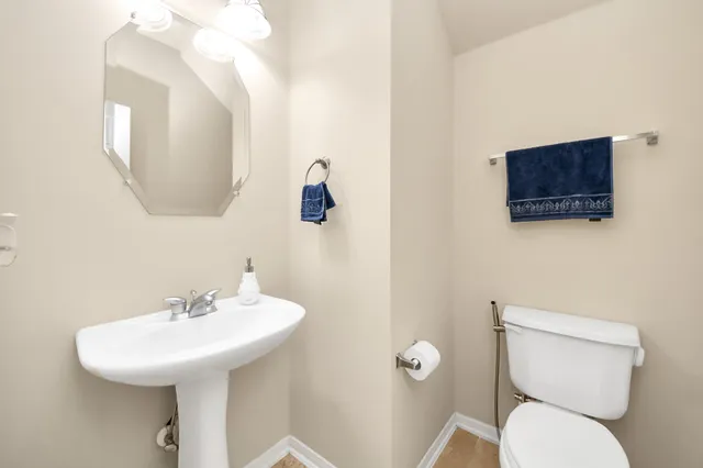 a bathroom with a toilet a sink and mirror