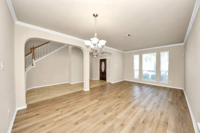 a view of a room with wooden floor and chandelier
