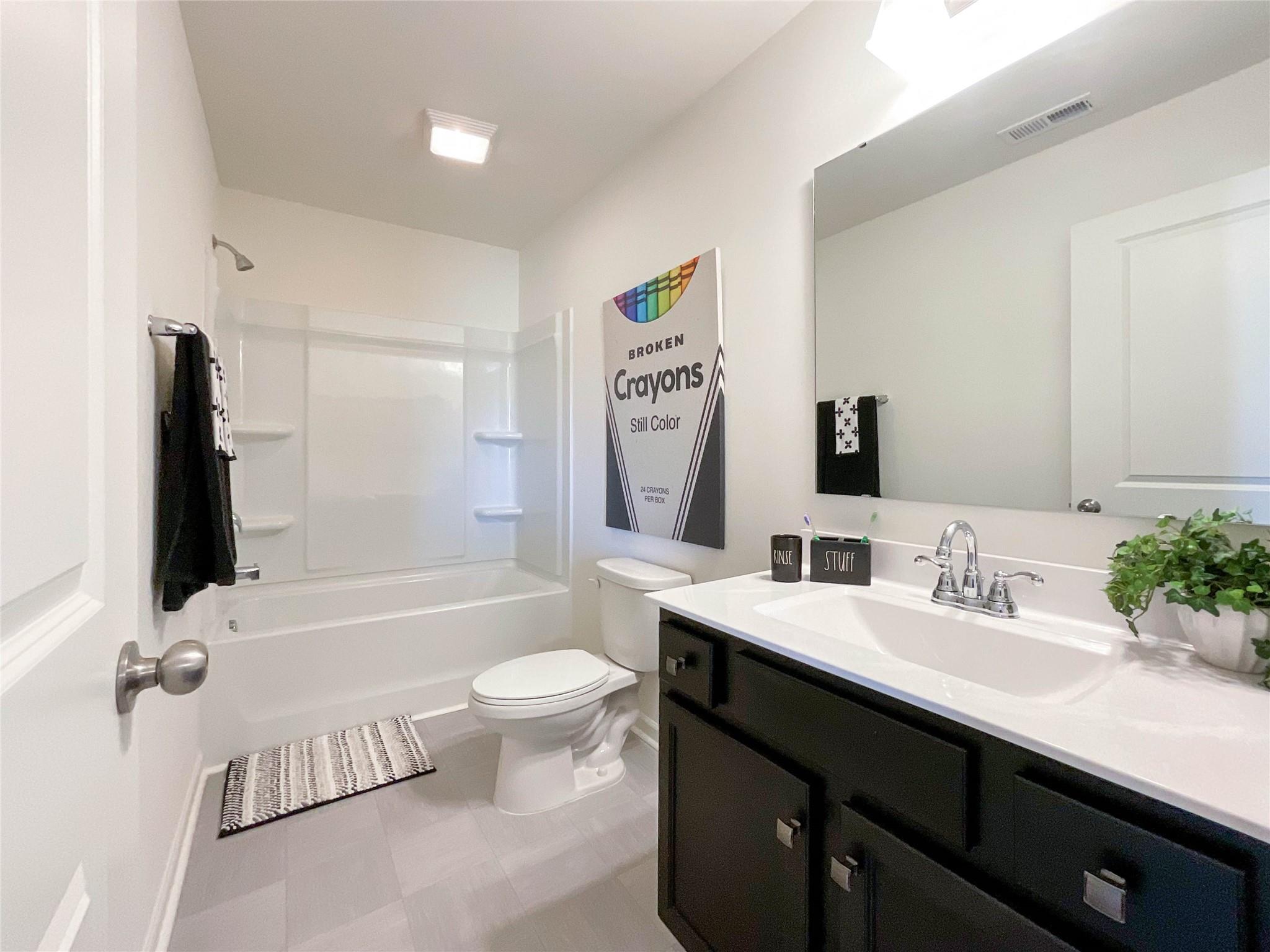 717 Alexander Commons Drive Monroe, NC 28112 - Photo 20 of 33 a bathroom with a granite countertop sink toilet a large mirror a bathtub and shower