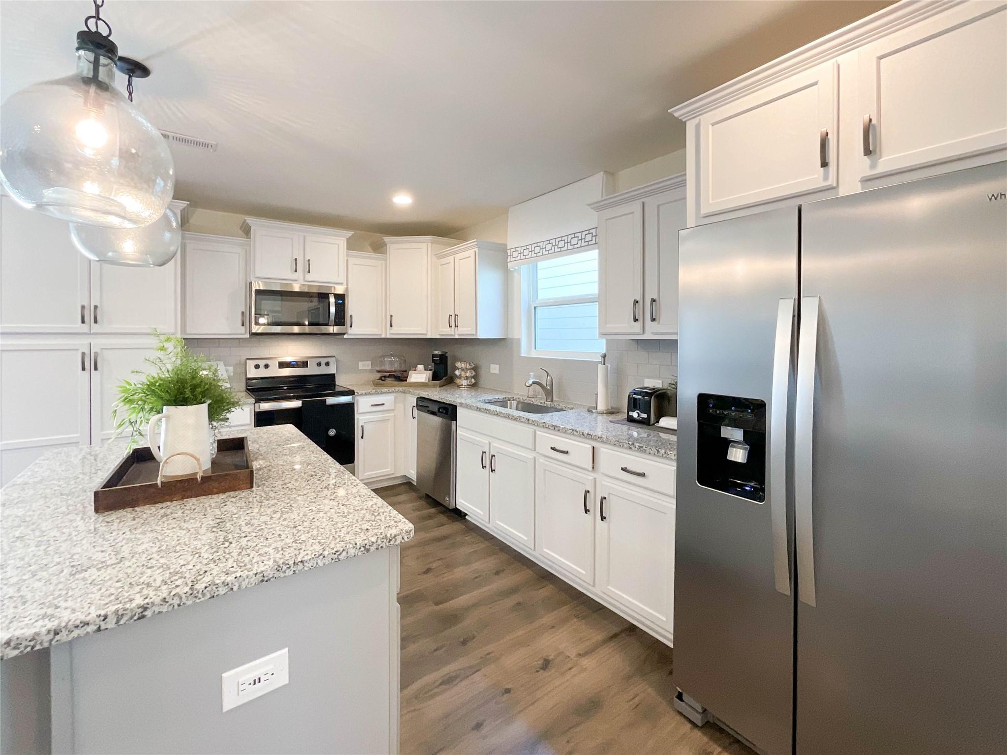 717 Alexander Commons Drive Monroe, NC 28112 - Photo 8 of 33 a kitchen with kitchen island granite countertop stainless steel appliances cabinets a sink and a counter top space
