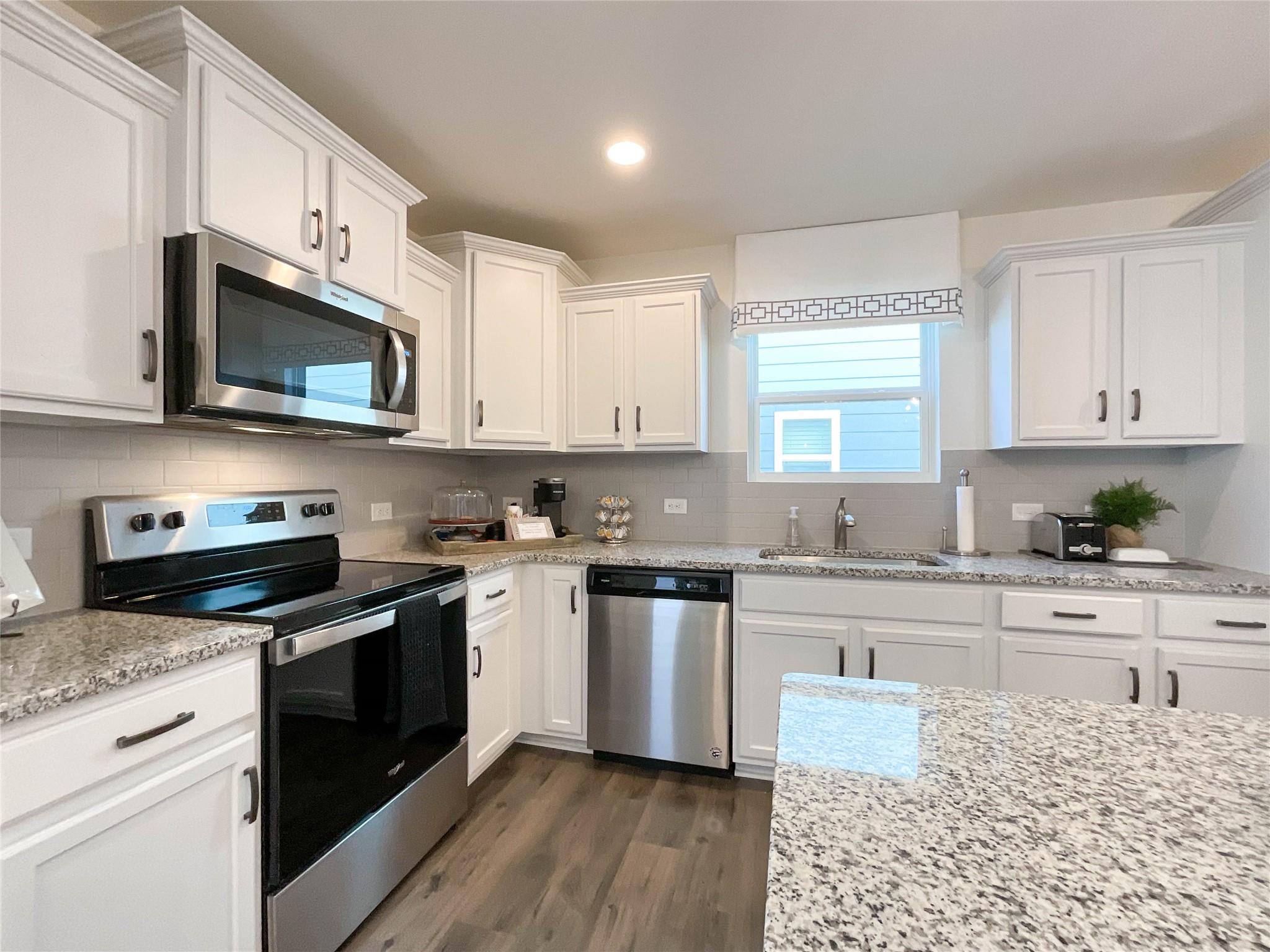 717 Alexander Commons Drive Monroe, NC 28112 - Photo 9 of 33 a kitchen with stainless steel appliances granite countertop a stove a sink a microwave and cabinets
