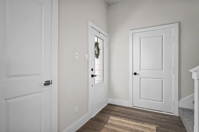 a kitchen with stainless steel appliances white cabinets and wooden floor