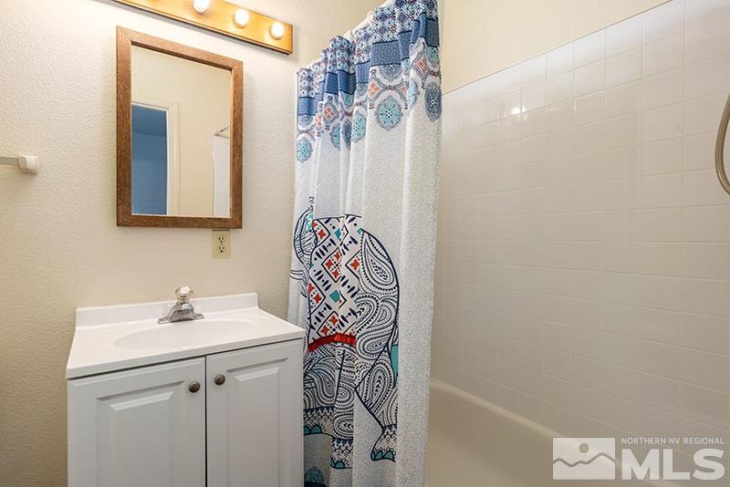 1420 Clough Road Reno, NV 89509 - Photo 13 of 25 a bathroom with a sink a mirror and a shower