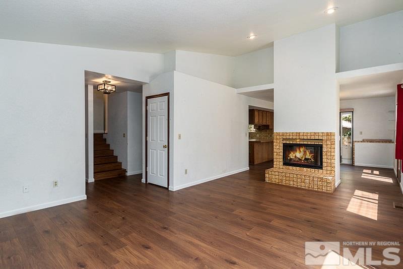 1420 Clough Road Reno, NV 89509 - Photo 3 of 25 an empty room with wooden floor fireplace and staircase