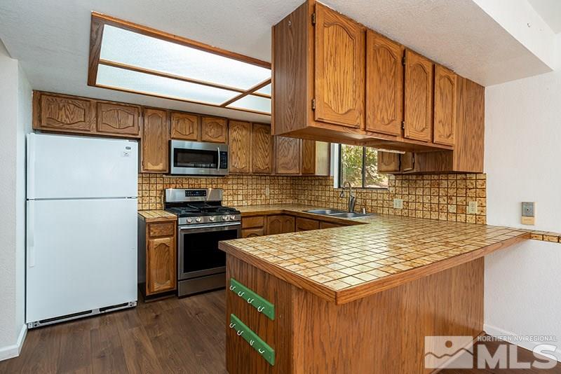1420 Clough Road Reno, NV 89509 - Photo 8 of 25 a kitchen with a stove a refrigerator and a sink