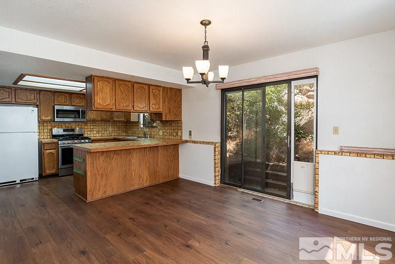 1420 Clough Road Reno, NV 89509 - Photo 9 of 25 a kitchen with stainless steel appliances granite countertop a refrigerator a stove top oven a sink and wooden floors