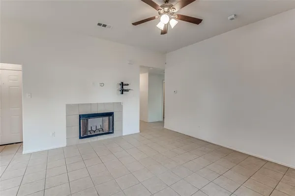 an empty room with windows and fireplace