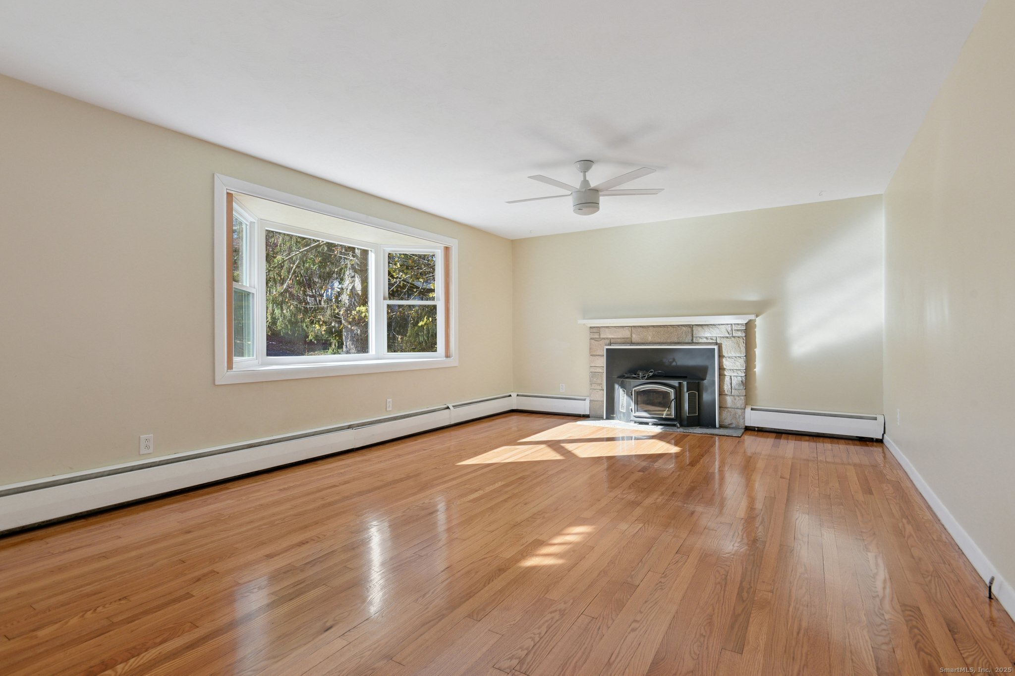 109 Valley Road Groton, CT 06340 - Photo 2 of 28 a view of an empty room with wooden floor fireplace and a window
