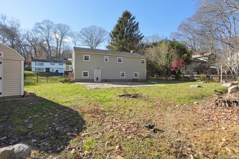 a view of a house with backyard and trees